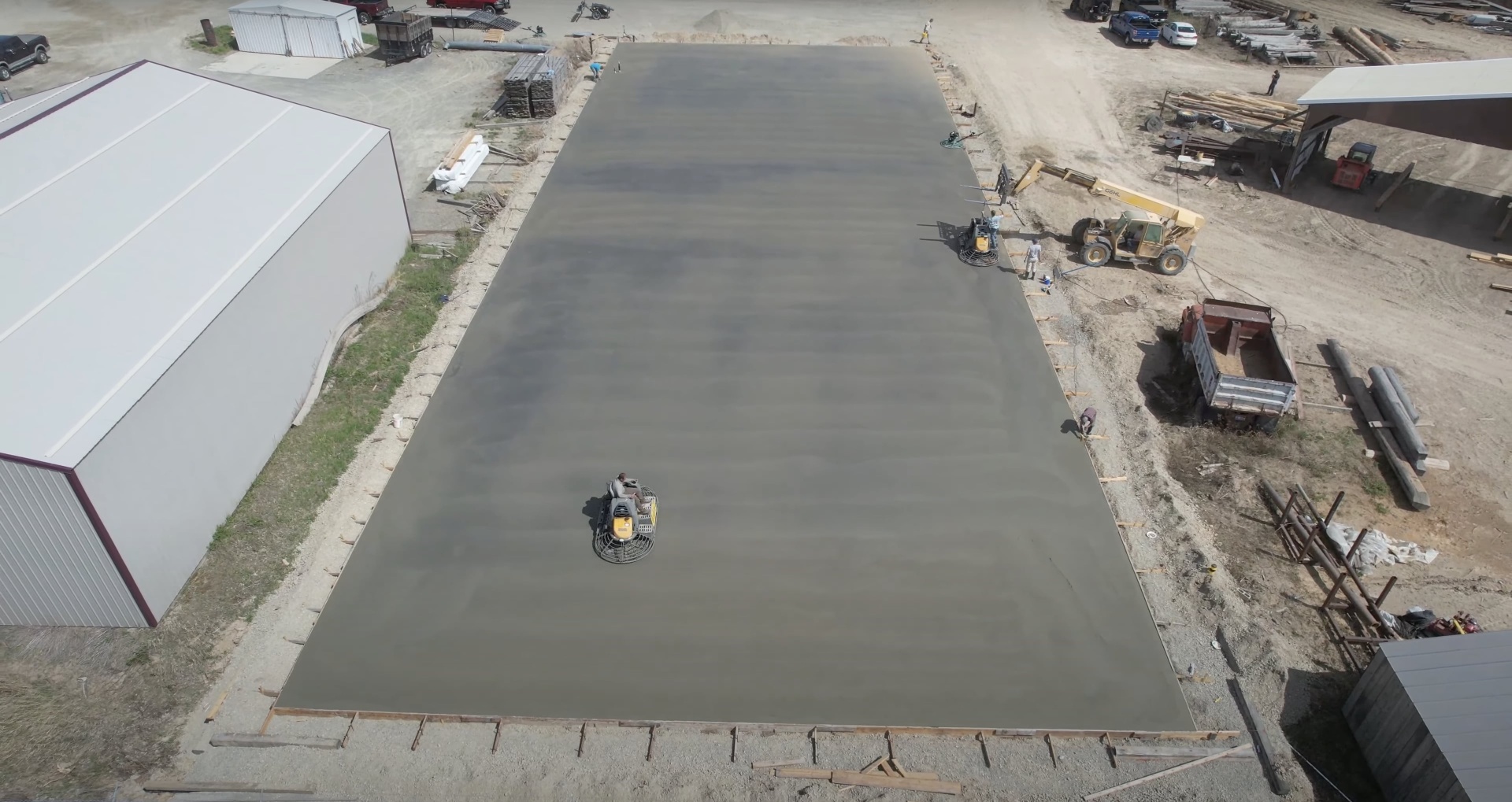 Professional concrete slab installation from aerial perspective Aerial view of large concrete slab being finished